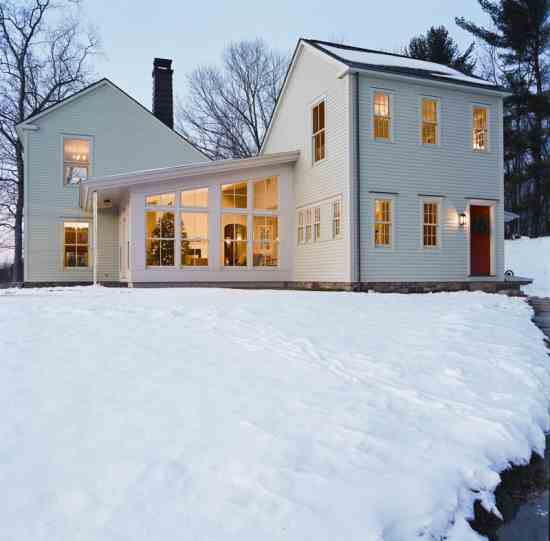 Cathy Grier and Michele Steckler’s Columbia County, New York, home beckons visitors in from the cold. Endowed with the stateliness of a pair of saltbox houses, it also features more casual screened porches and terraces. The building is sited so it receives passive solar heat in winter and shading from the roof overhang in summer.